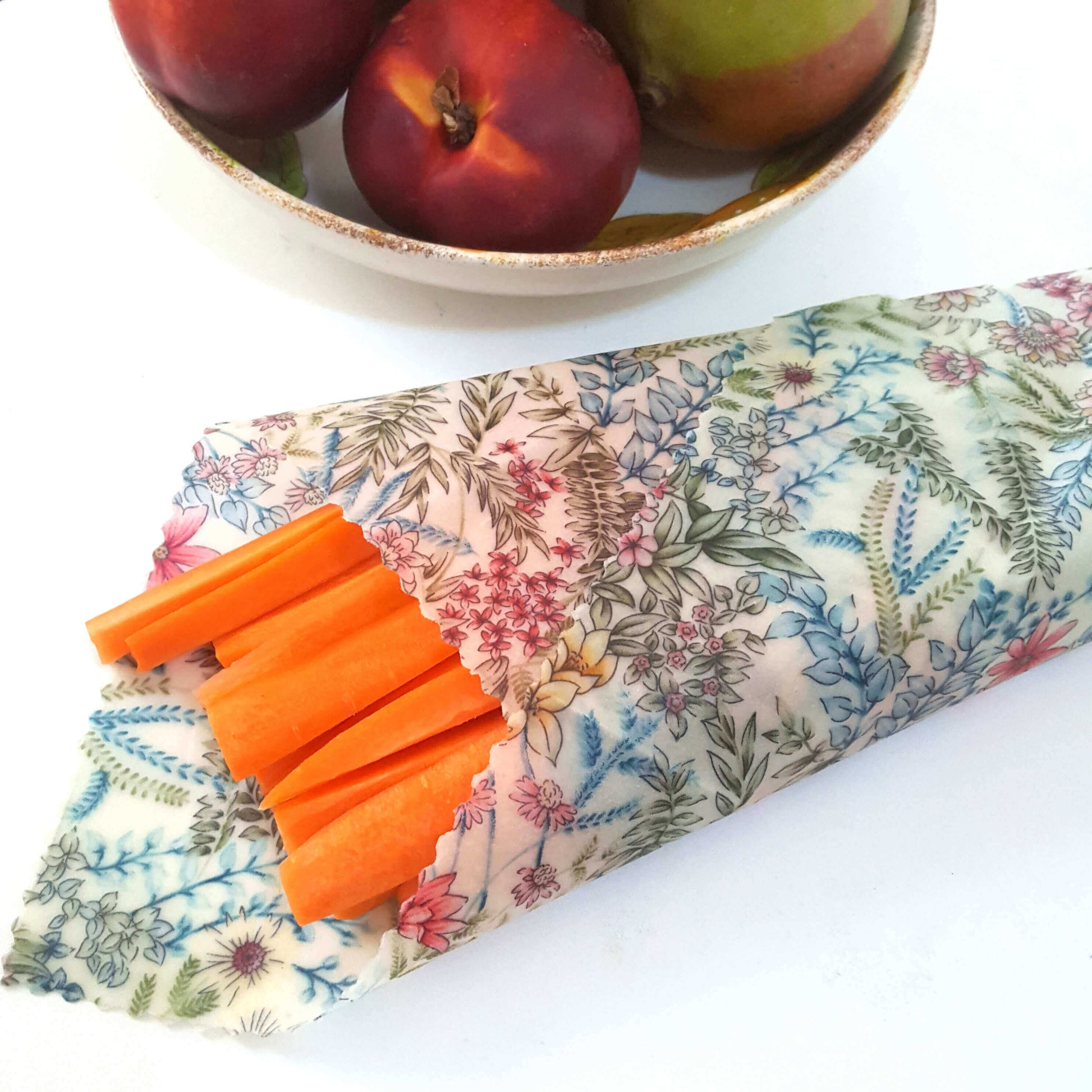 Reusable Beeswax Food Wraps 100% Hand Made in the UK by Honey Bee Good. Planet-Kind single large beeswax wrap in Botanical pattern as flatlay with carrots