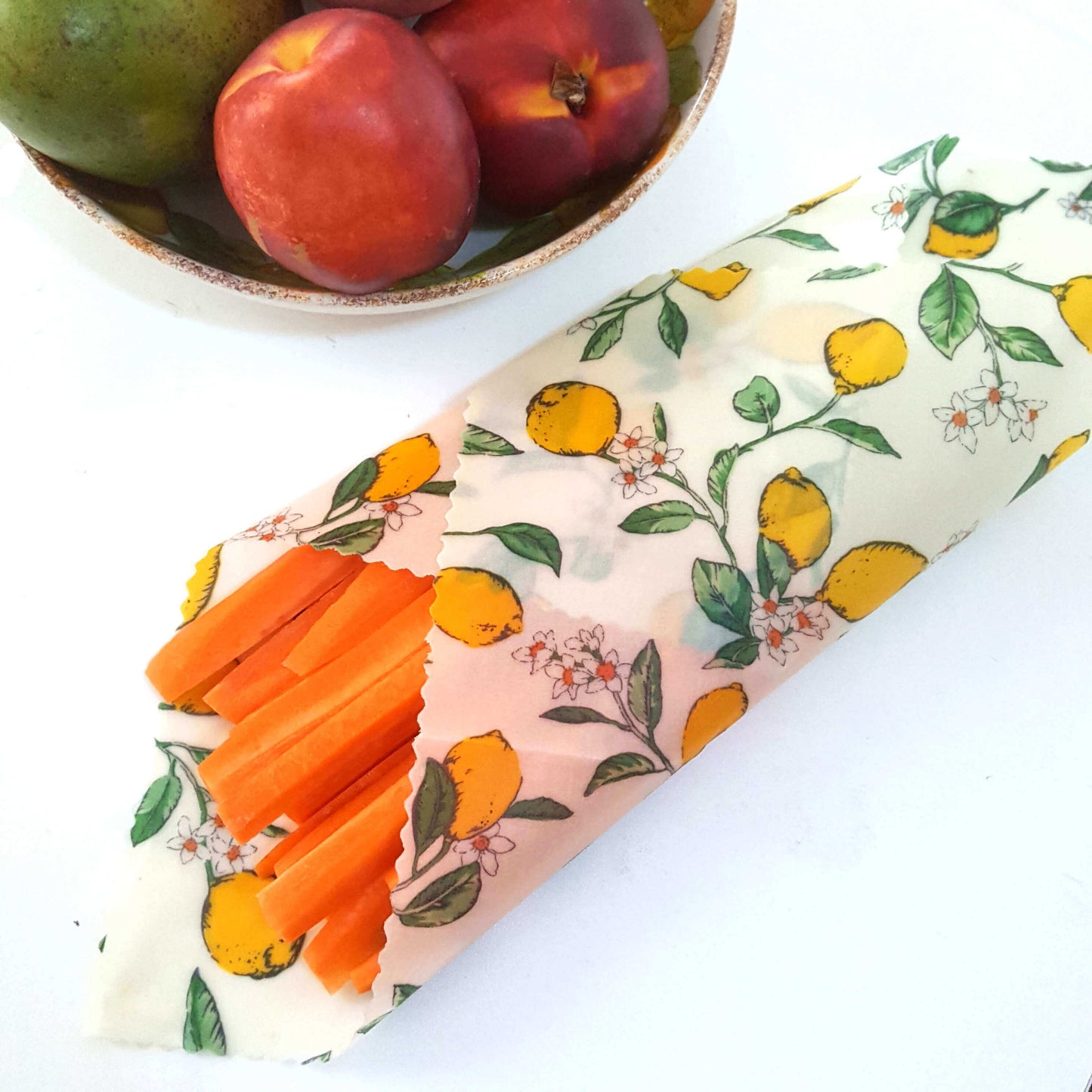 Reusable Beeswax Food Wraps 100% Hand Made in the UK by Honey Bee Good. Planet-Kind single large beeswax wrap in Lemons pattern as flatlay with carrots